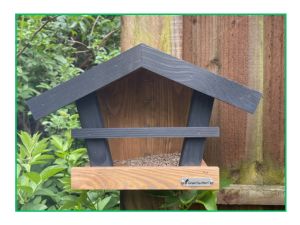 wooden bird feeder on garden fence