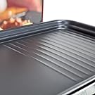 Family gathered around a raclette grill sharing a fun, hands-on meal