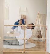 Baby stops in front of black gate at top of stairs