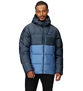 Man walking on grassy hillside wearing Marmot insulated jacket and hiking pants