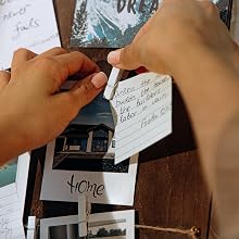 Personalized wooden prayer board with photos and notes, with a blurred family in the background