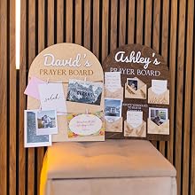 Hands placing a note on a personalized wooden prayer board with clips