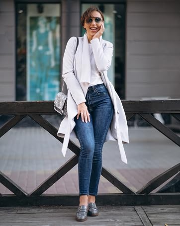 a youth women wearing a pair of blue patent leather loafers and walks on street.