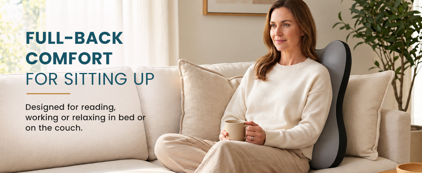Woman holding a mug on a couch with a BLISSBURY backrest cushion supporting her back.