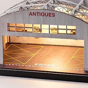 Overhead view of the empty hangar with exposed roof trusses and marked floor
